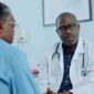 hispanic doctor consulting with black elderly patient bright clinic 85x85